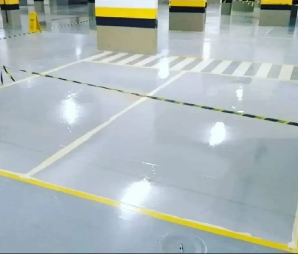 Garagem de prédio com piso e vagas pintados pela RP Pinturas no Guarujá