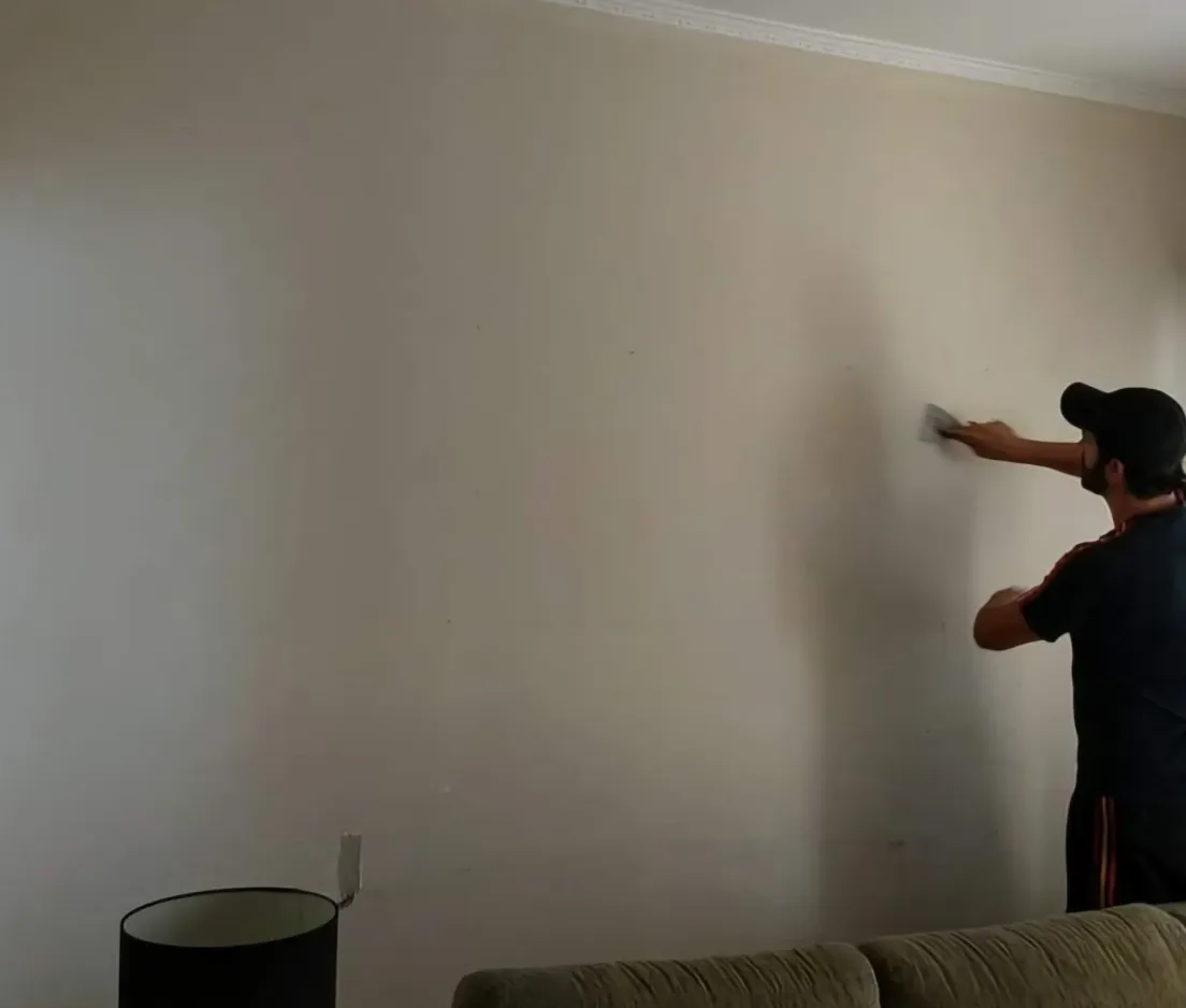 Pintor da RP Pinturas pintando parede interna de residência no Guarujá